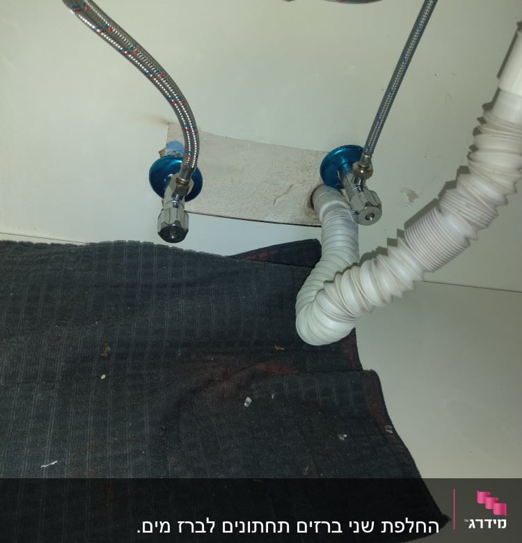 צינורות מתכת וגומי מתחת לכיור עם מחברים